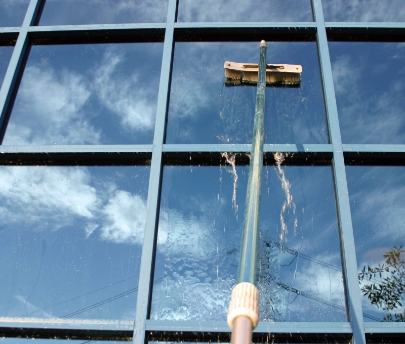 A window cleaner is cleaning the outside of a building.